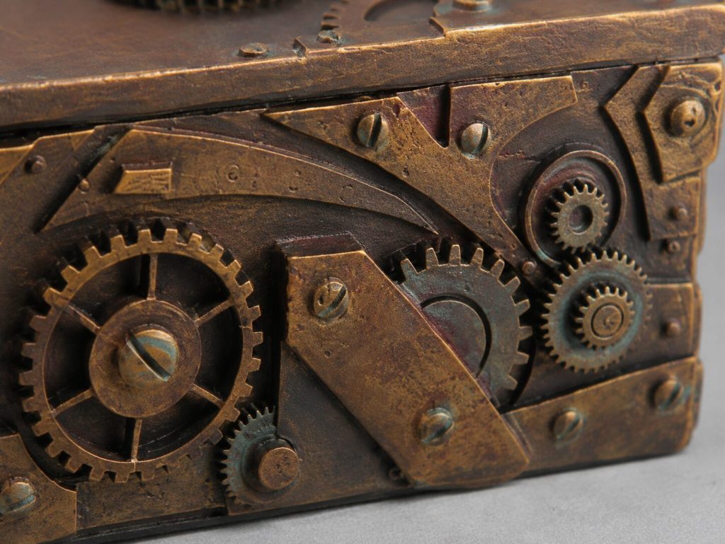 Trinket box exterior close-up - gear detail, rivet pattern, rust/gold/brown color distribution visible